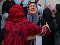 Palestinians are mourning by the bodies of relatives who were killed in an Israeli bombardment, at the al-Aqsa hospital in Deir Balah in the...