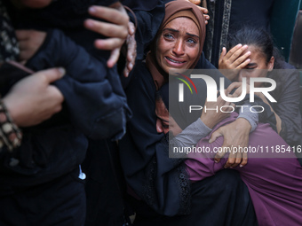 Palestinians are mourning by the bodies of relatives who were killed in an Israeli bombardment, at the al-Aqsa hospital in Deir Balah in the...