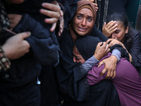 Palestinians are mourning by the bodies of relatives who were killed in an Israeli bombardment, at the al-Aqsa hospital in Deir Balah in the...