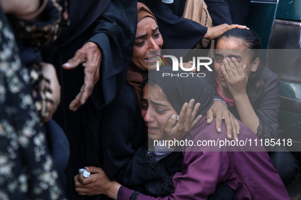 Palestinians are mourning by the bodies of relatives who were killed in an Israeli bombardment, at the al-Aqsa hospital in Deir Balah in the...