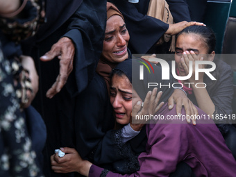 Palestinians are mourning by the bodies of relatives who were killed in an Israeli bombardment, at the al-Aqsa hospital in Deir Balah in the...