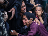 Palestinians are mourning by the bodies of relatives who were killed in an Israeli bombardment, at the al-Aqsa hospital in Deir Balah in the...