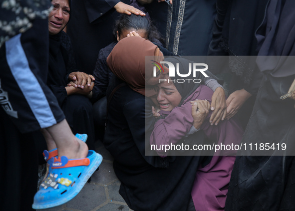 Palestinians are mourning by the bodies of relatives who were killed in an Israeli bombardment, at the al-Aqsa hospital in Deir Balah in the...