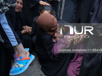 Palestinians are mourning by the bodies of relatives who were killed in an Israeli bombardment, at the al-Aqsa hospital in Deir Balah in the...