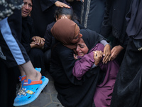 Palestinians are mourning by the bodies of relatives who were killed in an Israeli bombardment, at the al-Aqsa hospital in Deir Balah in the...