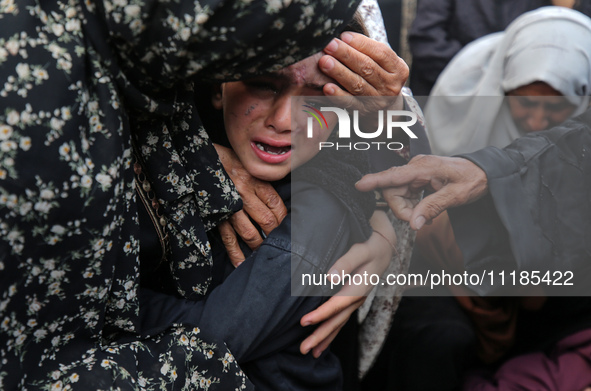 Palestinians are mourning by the bodies of relatives who were killed in an Israeli bombardment, at the al-Aqsa hospital in Deir Balah in the...