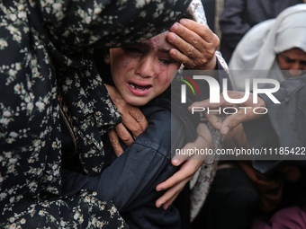 Palestinians are mourning by the bodies of relatives who were killed in an Israeli bombardment, at the al-Aqsa hospital in Deir Balah in the...