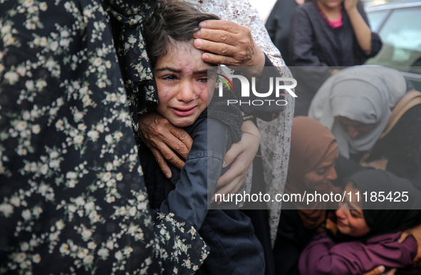 Palestinians are mourning by the bodies of relatives who were killed in an Israeli bombardment, at the al-Aqsa hospital in Deir Balah in the...