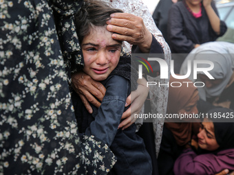 Palestinians are mourning by the bodies of relatives who were killed in an Israeli bombardment, at the al-Aqsa hospital in Deir Balah in the...