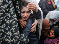 Palestinians are mourning by the bodies of relatives who were killed in an Israeli bombardment, at the al-Aqsa hospital in Deir Balah in the...