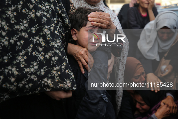 Palestinians are mourning by the bodies of relatives who were killed in an Israeli bombardment, at the al-Aqsa hospital in Deir Balah in the...