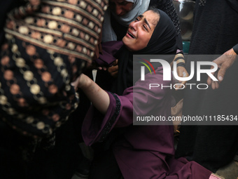 Palestinians are mourning by the bodies of relatives who were killed in an Israeli bombardment, at the al-Aqsa hospital in Deir Balah in the...