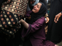 Palestinians are mourning by the bodies of relatives who were killed in an Israeli bombardment, at the al-Aqsa hospital in Deir Balah in the...