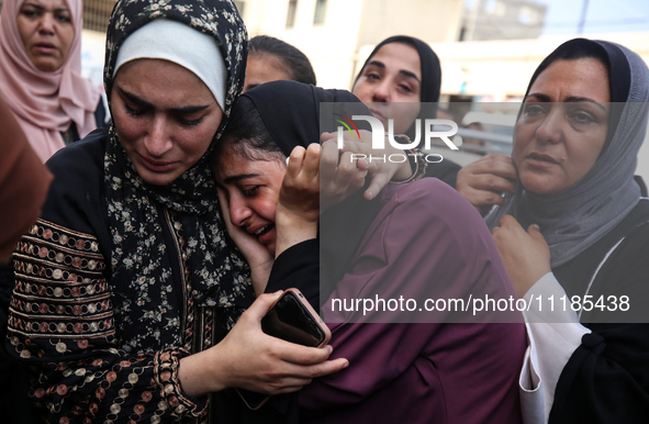 Palestinians are mourning by the bodies of relatives who were killed in an Israeli bombardment, at the al-Aqsa hospital in Deir Balah in the...