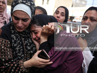 Palestinians are mourning by the bodies of relatives who were killed in an Israeli bombardment, at the al-Aqsa hospital in Deir Balah in the...