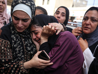 Palestinians are mourning by the bodies of relatives who were killed in an Israeli bombardment, at the al-Aqsa hospital in Deir Balah in the...