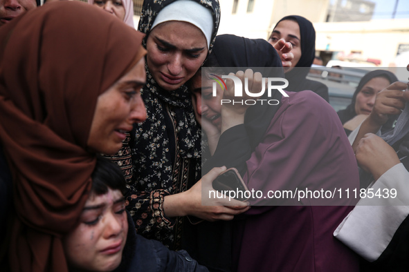 Palestinians are mourning by the bodies of relatives who were killed in an Israeli bombardment, at the al-Aqsa hospital in Deir Balah in the...