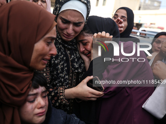 Palestinians are mourning by the bodies of relatives who were killed in an Israeli bombardment, at the al-Aqsa hospital in Deir Balah in the...