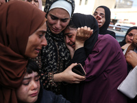 Palestinians are mourning by the bodies of relatives who were killed in an Israeli bombardment, at the al-Aqsa hospital in Deir Balah in the...