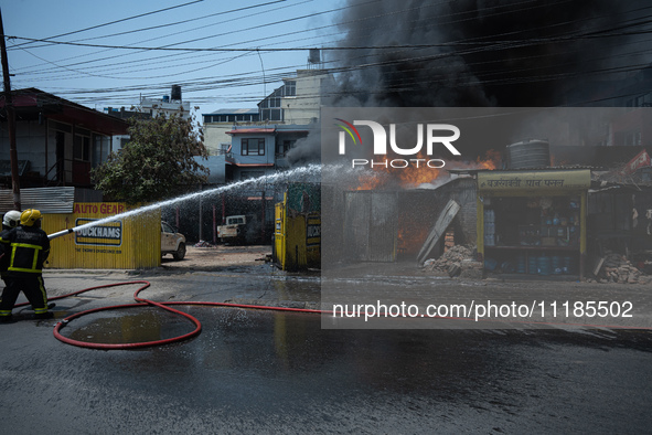 Firefighters are dousing flames as a fire spreads from a vehicle workshop to adjacent shops in Sankhamul, Kathmandu, causing extensive damag...