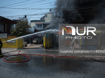 Firefighters are dousing flames as a fire spreads from a vehicle workshop to adjacent shops in Sankhamul, Kathmandu, causing extensive damag...