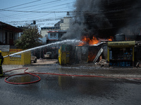 Firefighters are dousing flames as a fire spreads from a vehicle workshop to adjacent shops in Sankhamul, Kathmandu, causing extensive damag...