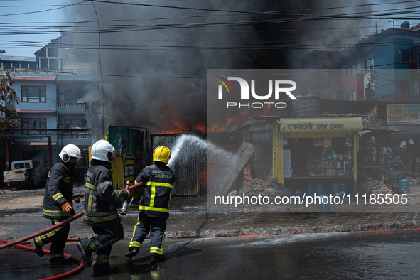 Firefighters are dousing flames as a fire spreads from a vehicle workshop to adjacent shops in Sankhamul, Kathmandu, causing extensive damag...