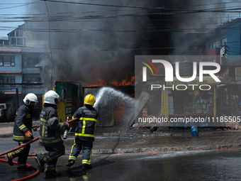 Firefighters are dousing flames as a fire spreads from a vehicle workshop to adjacent shops in Sankhamul, Kathmandu, causing extensive damag...