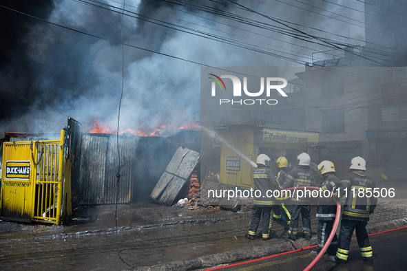 Firefighters are dousing flames as a fire spreads from a vehicle workshop to adjacent shops in Sankhamul, Kathmandu, causing extensive damag...