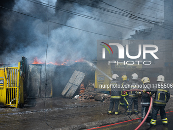 Firefighters are dousing flames as a fire spreads from a vehicle workshop to adjacent shops in Sankhamul, Kathmandu, causing extensive damag...