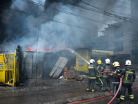 Firefighters are dousing flames as a fire spreads from a vehicle workshop to adjacent shops in Sankhamul, Kathmandu, causing extensive damag...