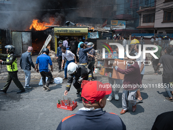 Shop owners are salvaging belongings as a fire spreads from a vehicle workshop to adjacent shops in Sankhamul, Kathmandu, causing extensive...