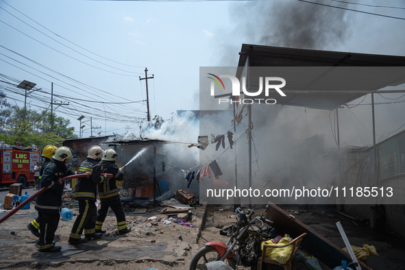 Firefighters are dousing flames as a fire spreads from a vehicle workshop to adjacent shops in Sankhamul, Kathmandu, causing extensive damag...