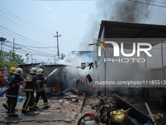 Firefighters are dousing flames as a fire spreads from a vehicle workshop to adjacent shops in Sankhamul, Kathmandu, causing extensive damag...