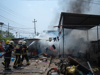 Firefighters are dousing flames as a fire spreads from a vehicle workshop to adjacent shops in Sankhamul, Kathmandu, causing extensive damag...