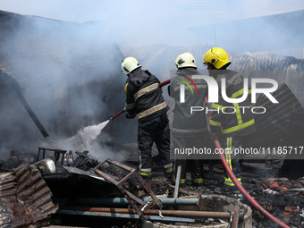 Firefighters and Nepal Police attempt to control the fire that engulfed a vehicle service center in Kathmandu, Nepal, on April 28, 2024.(