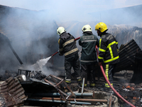 Firefighters and Nepal Police attempt to control the fire that engulfed a vehicle service center in Kathmandu, Nepal, on April 28, 2024.(