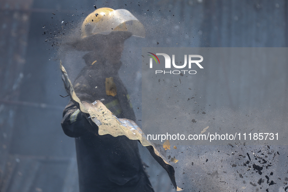 Firefighters and Nepal Police attempt to control the fire that engulfed a vehicle service center in Kathmandu, Nepal, on April 28, 2024.