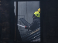 Firefighters and Nepal Police attempt to control the fire that engulfed a vehicle service center in Kathmandu, Nepal, on April 28, 2024.(