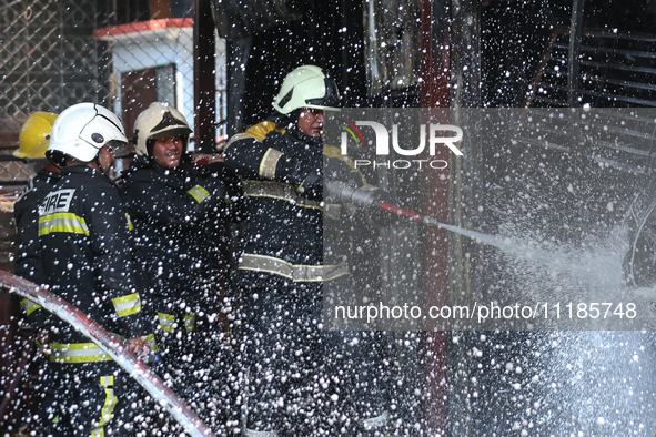 Firefighters and Nepal Police attempt to control the fire that engulfed a vehicle service center in Kathmandu, Nepal, on April 28, 2024.