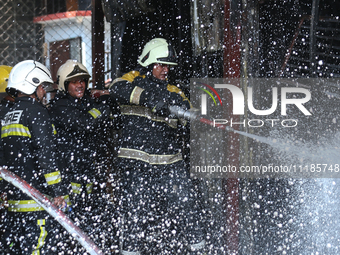 Firefighters and Nepal Police attempt to control the fire that engulfed a vehicle service center in Kathmandu, Nepal, on April 28, 2024.(