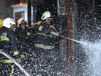 Firefighters and Nepal Police attempt to control the fire that engulfed a vehicle service center in Kathmandu, Nepal, on April 28, 2024.(