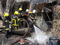 Firefighters and Nepal Police attempt to control the fire that engulfed a vehicle service center in Kathmandu, Nepal, on April 28, 2024.(