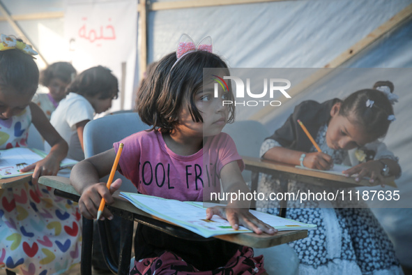 Palestinian children are attending class at a makeshift school in a camp for displaced Palestinians in Deir El-Balah, in the central Gaza St...