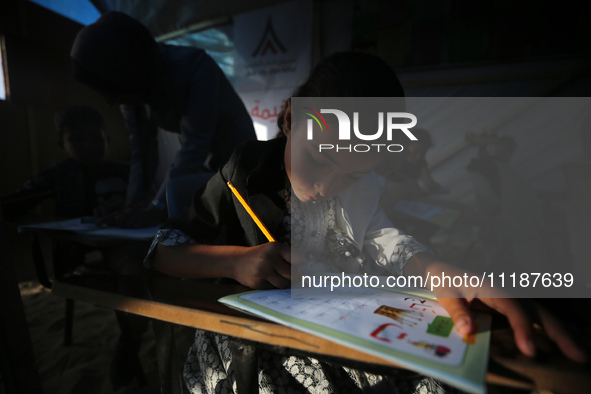 Palestinian children are attending class at a makeshift school in a camp for displaced Palestinians in Deir El-Balah, in the central Gaza St...