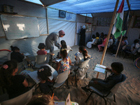 Palestinian children are attending class at a makeshift school in a camp for displaced Palestinians in Deir El-Balah, in the central Gaza St...