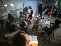 Palestinian children are attending class at a makeshift school in a camp for displaced Palestinians in Deir El-Balah, in the central Gaza St...