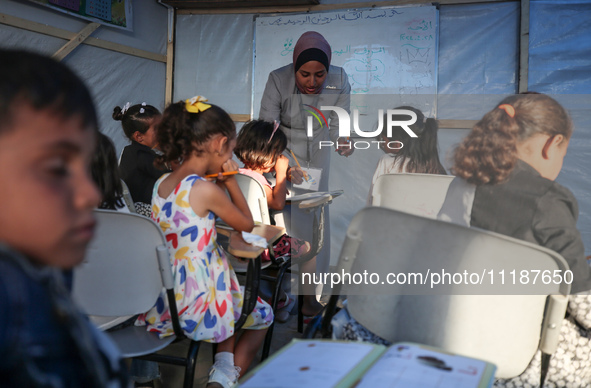 Palestinian children are attending class at a makeshift school in a camp for displaced Palestinians in Deir El-Balah, in the central Gaza St...