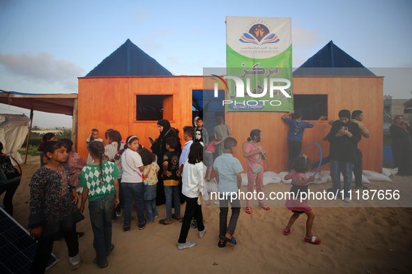 Palestinian children are attending class at a makeshift school in a camp for displaced Palestinians in Deir El-Balah, in the central Gaza St...