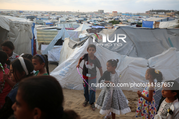 Palestinian children are attending class at a makeshift school in a camp for displaced Palestinians in Deir El-Balah, in the central Gaza St...